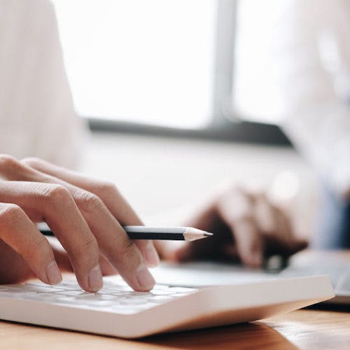 Woman typing on calculator>